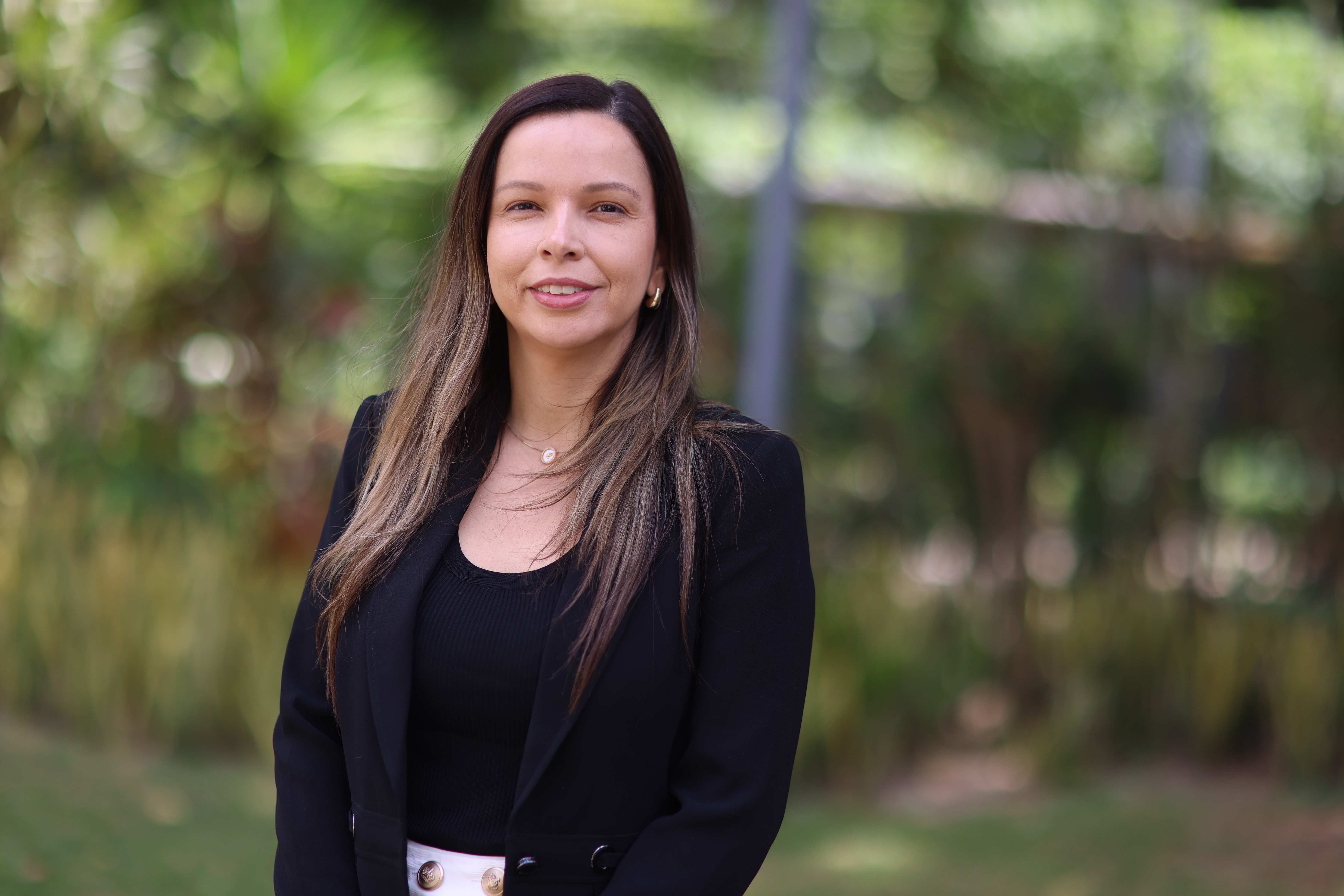 Laila Freitas posa para a foto, ela está com uma blusa preta